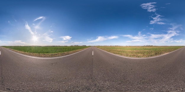 Panorama esférico sem costura visão de ângulo de 360 graus em estrada de asfalto sem tráfego entre campos na noite antes do pôr do sol com céu nublado 360 panorama em projeção equirretangular VR conteúdo AR