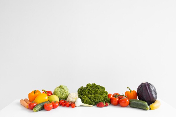 Panorama de frutas y verduras frescas sobre fondo blanco.