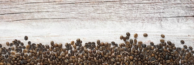 Foto panorama de los granos de café en la textura de la madera