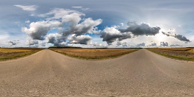 Panorama hdri esférico completo sem costura vista de ângulo de 360 graus na estrada de asfalto entre campos no dia de outono com nuvens impressionantes em projeção equirretangular pronta para conteúdo de realidade virtual VR AR
