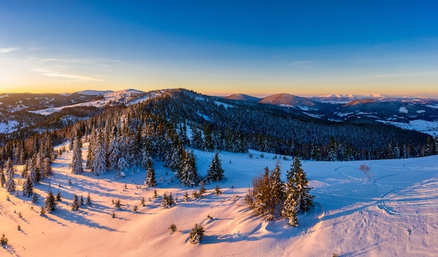 Panorama de invierno mágico de hermosas laderas nevadas en una estación de esquí en Europa en un día helado soleado y sin viento. El concepto de recreación activa en invierno.