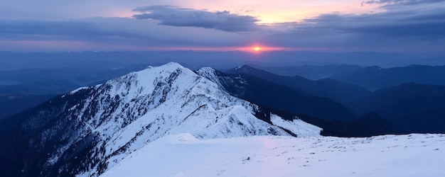 Panorama de invierno. Paisaje de montaña con el sol poniente