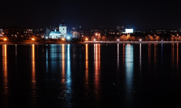 Panorama de las luces de la ciudad nocturna y reflejos en el lago en Ternopil Ucrania Europa