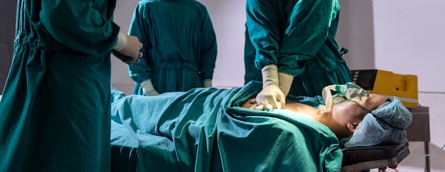 Foto panorama el médico y la enfermera cirujanos realizan rcp en la panorámica del paciente.