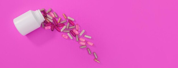 Panorama mehrfarbige Pillen und Kapseln auf rosafarbenem Hintergrund