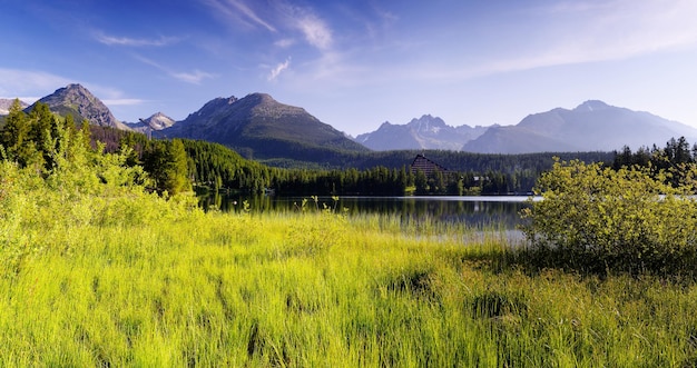 Panorama de montaña por la mañana con lago y exuberante hierba. Eslovaquia, Europa. Lago Strbske Pleso