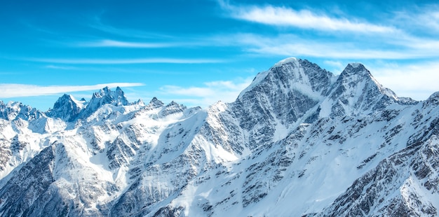 Panorama de montañas blancas en la nieve. Paisaje con picos azules