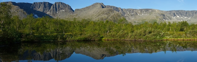 Panorama con las montañas del Khibiny, cielo reflejado en el lago Small Vudyavr