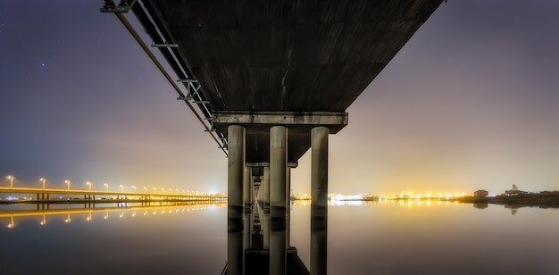 Panorama nocturno con pilares de un puente.