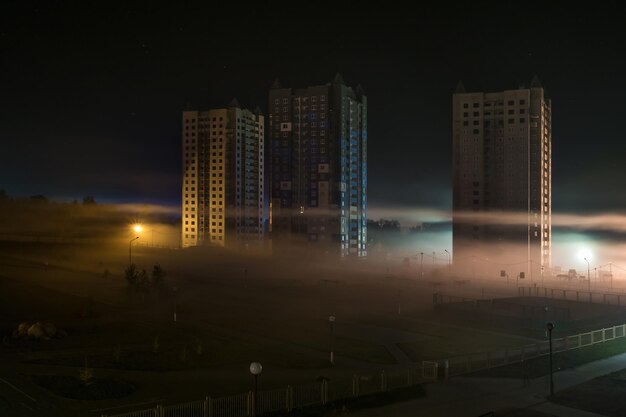 Panorama noturno da área residencial com arranha-céus no nevoeiro no início da manhã