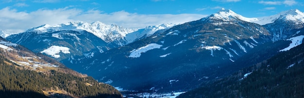 Panorama de país de montaña de invierno con pueblo en pendiente (Austria).