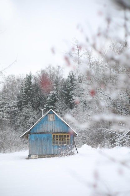 Panorama de paisaje invernal con casa de madera en el bosque Cabaña cubierta de nieve Concepto de vacaciones de Navidad y vacaciones de invierno