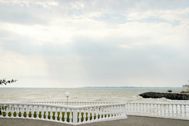 Panorama del paseo marítimo con un parapeto en un día soleado junto al mar.