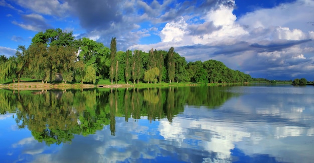 Panorama del reflejo del cielo nublado en el lago