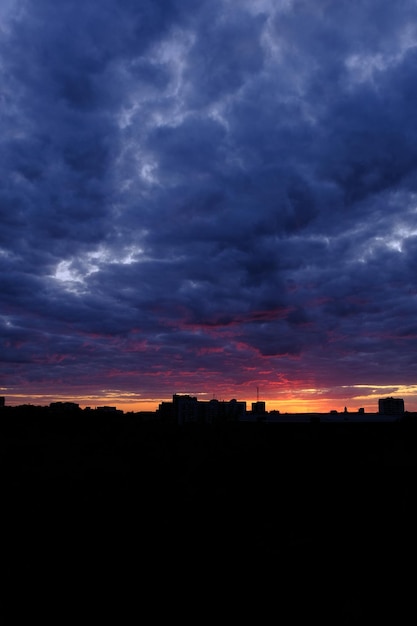 Panorama de la silueta del centro de la ciudad de Sumy al atardecer con rascacielos y cielo colorido sobre el río