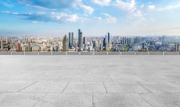 Panorama-Skyline und leere quadratische Bodenfliesen mit modernen Gebäuden