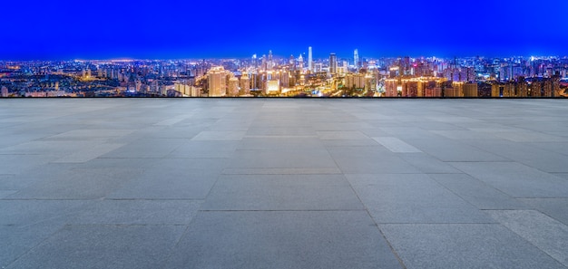 Panorama-Skyline und leere quadratische Bodenfliesen mit modernen Gebäuden