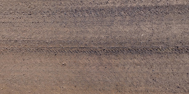 Panorama de la superficie desde arriba del camino de ripio con huellas de neumáticos de automóviles