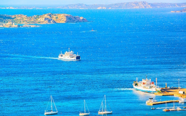 Panorama und Landschaft bei La Maddalena an der Costa Smeralda am Mittelmeer auf der italienischen Insel Sardinien. Boote in Sardegna im Sommer. Provinz Olbia. Gemischte Medien.