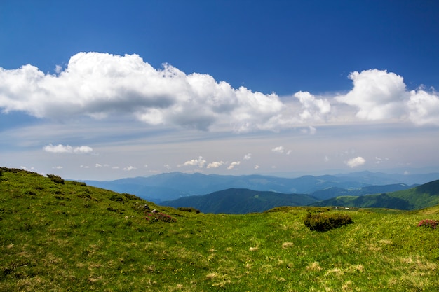 Panorama verde das montanhas sob o céu azul no dia ensolarado brilhante. Turismo e conceito de viagem, cópia espaço plano de fundo.