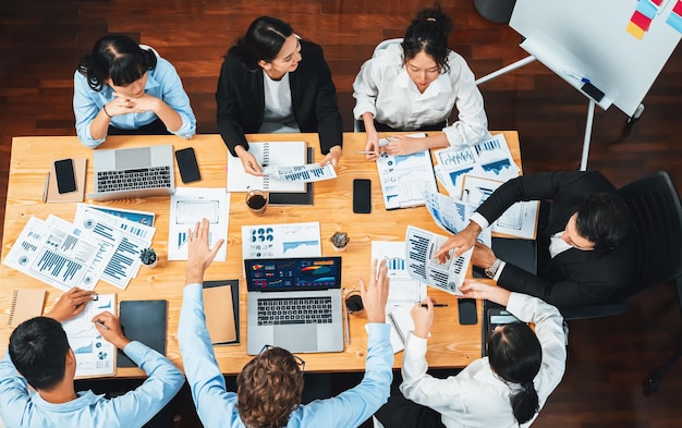 Panorama vista superior grupo diverso de equipo de analistas de negocios analizando datos financieros informe papel en la mesa de reuniones tabla de gráficos y tablero de instrumentos por análisis de inteligencia de negocios meticuloso