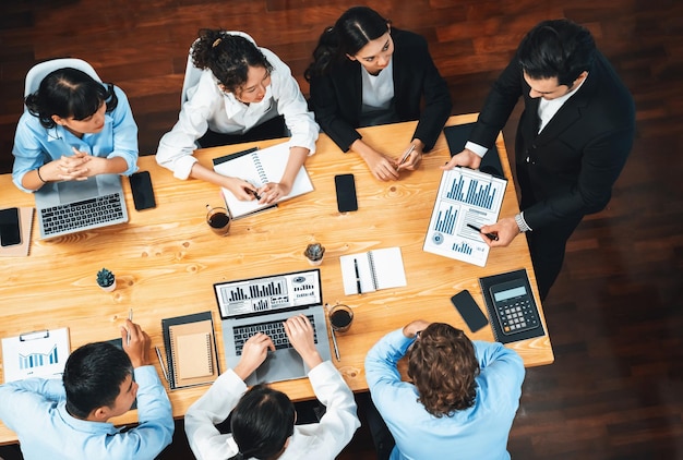 Panorama vista superior grupo diverso de equipo de analistas de negocios analizando papel de informe de datos financieros en la mesa de reuniones Tablero de gráficos y gráficos por análisis de inteligencia de negocios Meticuloso