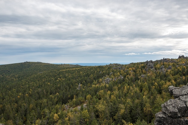 Panorama von Bergszenen im Nationalpark Kachkanar, Russland, Europa. Bewölktes Wetter, dramatischer blauer Himmel, weit entfernte grüne Bäume