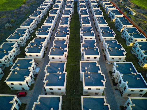 Panorama von oben auf eine Vielzahl von Wohnungen in der Stadt mit Straßen und Autos umgeben von Wiesen und Feldern