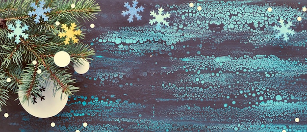 Panorama-Weihnachtshintergrund mit Tannenzweigen und Papierdekorationen auf fließendem Kunsthintergrund