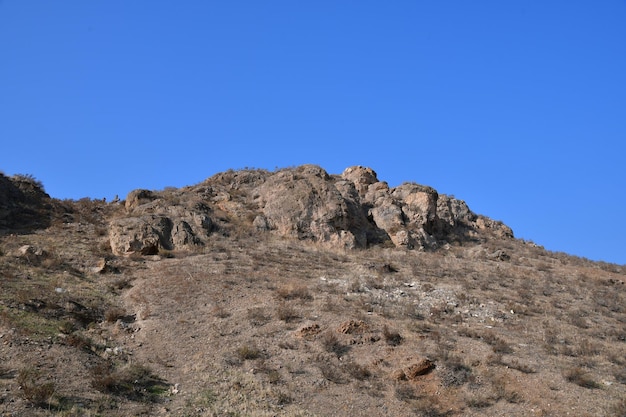 Panoramablick auf den Berg. Große Steine oben auf dem Berg. Berg gegen den blauen Himmel.