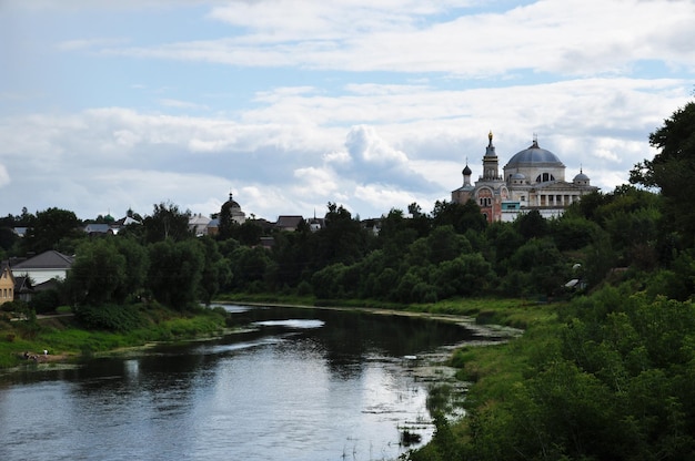 Panoramablick auf den Fluss Tvertsa und das Borisoglebsky-Kloster. Sommertag mit schönen Wolken am Himmel.