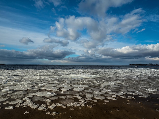 Foto panoramablick auf den frühlingsfluss eissplitter auf dem hintergrund der wolken bunte blauer himmel