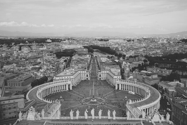 Panoramablick auf den Petersplatz und die Stadt Rom von der päpstlichen Basilika St. Peter (Petersdom). Sommertag und Leute gehen auf Platz