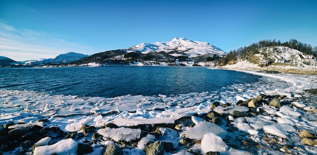 Panoramablick auf den schönen Wintersee mit schneebedeckten Bergen auf den Lofoten-Inseln in Nordnorwegen