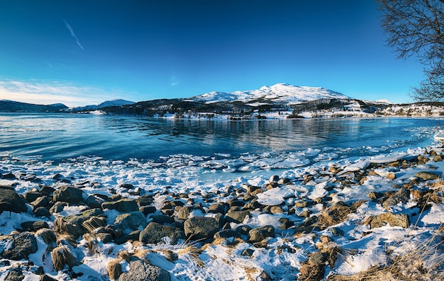 Panoramablick auf den schönen Wintersee mit schneebedeckten Bergen auf den Lofoten-Inseln in Nordnorwegen