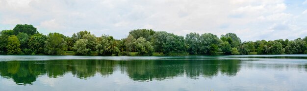 Foto panoramablick auf den wunderschönen see im park landschaft mit grünen bäumen des sees