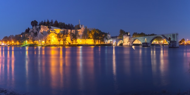 Panoramablick auf die berühmte mittelalterliche Brücke Saint Benezet und den Palast der Päpste während der blauen Abendstunde, Avignon, Südfrankreich