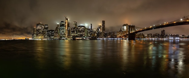 Panoramablick auf die Innenstadt von Manhattan und die Brooklyn Bridge in einer nebligen Nacht