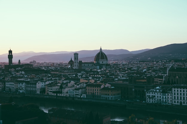 Panoramablick auf die Stadt Florenz mit Cattedrale di Santa Maria del Fiore und Palazzo Vecchio vom Piazzale Michelangelo (Michelangelo-Platz). Sonniger Sommertag und dramatischer blauer Himmel