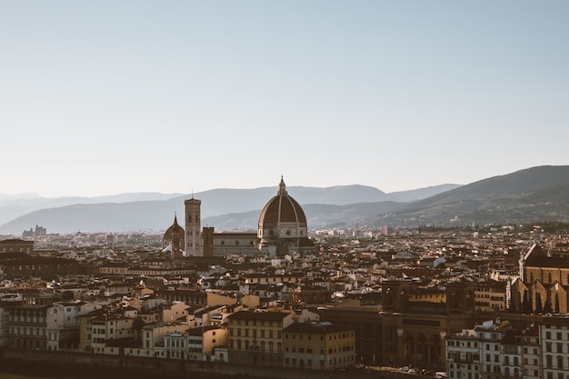 Panoramablick auf die Stadt Florenz mit Cattedrale di Santa Maria del Fiore und Palazzo Vecchio vom Piazzale Michelangelo (Michelangelo-Platz). Sonniger Sommertag und dramatischer blauer Himmel