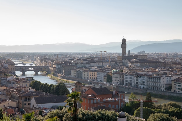 Panoramablick auf die Stadt Florenz mit Cattedrale di Santa Maria del Fiore und Palazzo Vecchio vom Piazzale Michelangelo (Michelangelo-Platz). Sonniger Sommertag und dramatischer blauer Himmel