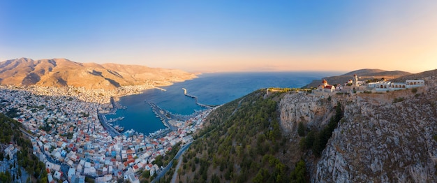 Foto panoramablick auf die stadt pothia, die hauptstadt von kalymnos, griechenland, und das kloster von agios savvas auf dem hügel links