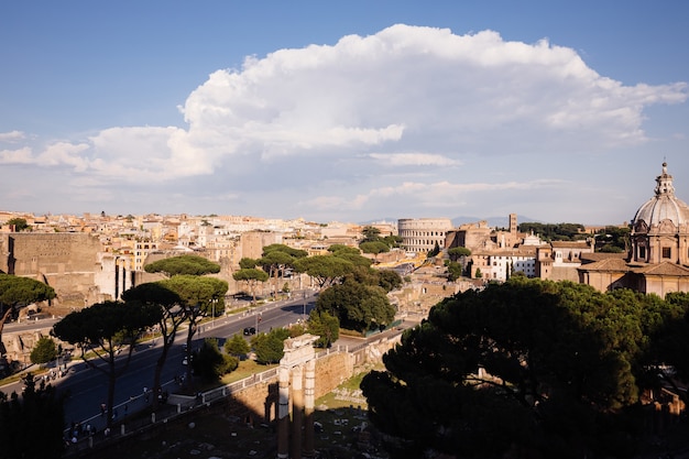 Panoramablick auf die Stadt Rom mit Forum Romanum und Kolosseum von Vittorio Emanuele II Monument auch bekannt als Vittoriano. Sonniger Sommertag und dramatischer blauer Himmel