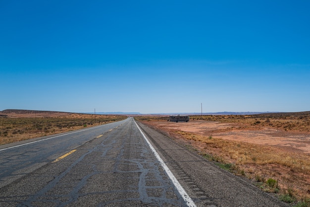 Panoramablick auf die Straße, die durch die karge Landschaft des amerikanischen Südwestens führt