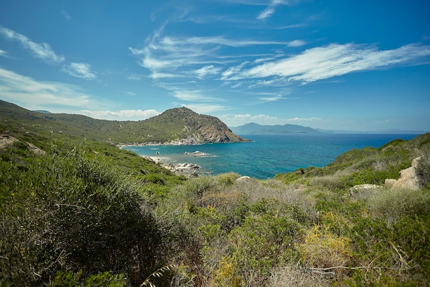 Panoramablick auf eine natürliche Bucht mit Meer und Bergen und mediterraner Vegetation