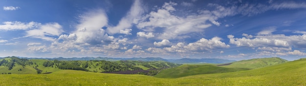 Panoramablick auf grüne Hügel und malerischen blauen Himmel mit weißen Wolken