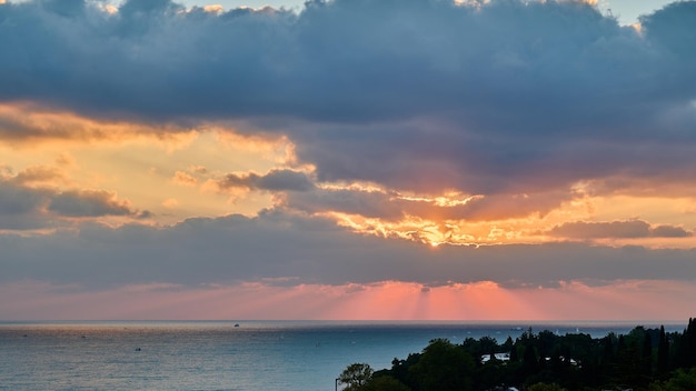 Panoramablick auf Sonnenstrahlen aus Wolken bei Sonnenuntergang