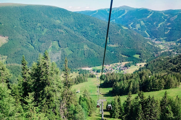 Foto panoramablick mit seilbahnen in den bergen und blauem himmel in bad kleinkirchheim, kärnten, österreich. österreichische hügel und grüne täler. naturlandschaft im freien. reisen und tourismus im sommer.