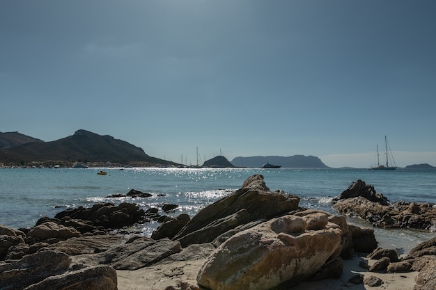 Panoramablick von den Felsen am Ufer des Meeres mit Yachten im Hintergrund der Berge und