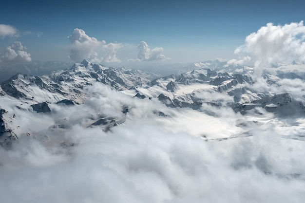 Panoramalandschaft aus der Luft mit Bergen, die teilweise hinter niedrigen Wolken versteckt sind Kaukasus Russland